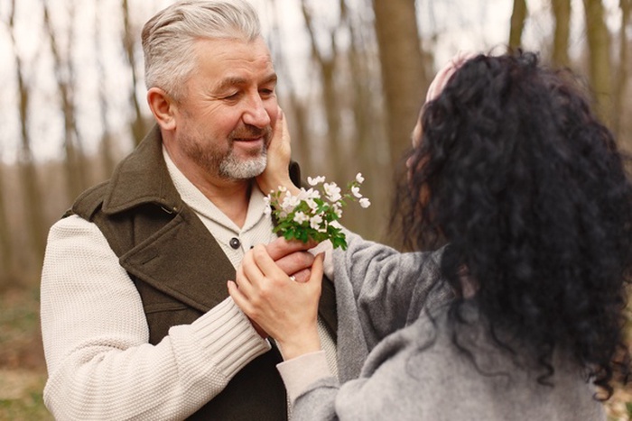 Senior couple sharing a romantic moment outdoors with flowers