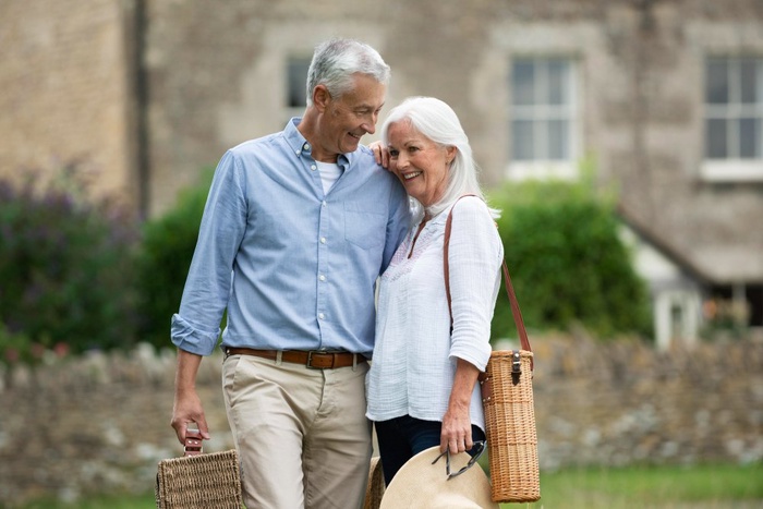 Senior couple walking closely together with picnic baskets in Littleton, Colorado