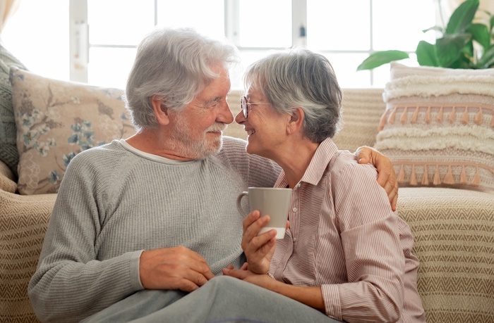 Senior couple sharing a warm moment together at home while relaxing on a sofa.