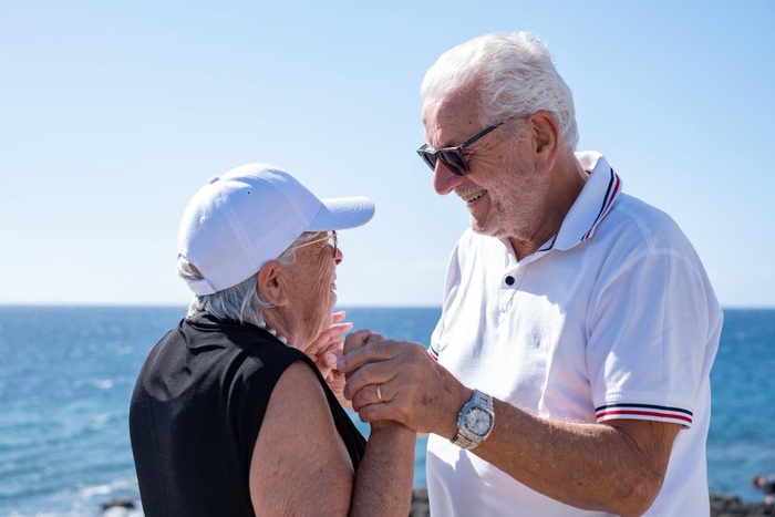 Older couple holding hands by the ocean in Ponte Vedra Beach, Florida