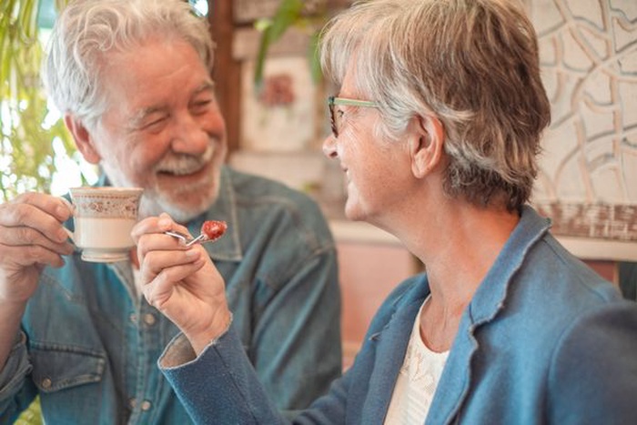 Senior couple enjoying coffee and dessert together at a café 