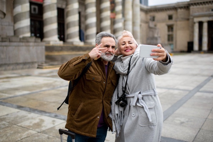 Senior couple taking a selfie outside a historic building in Salisbury, England