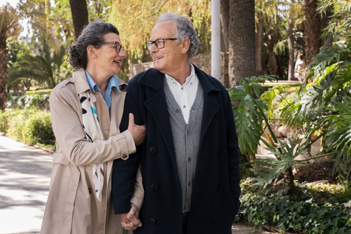 Mature couple walking along shaded Manly path