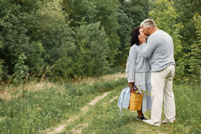 Older couple sharing a quiet conversation in a leafy Weybridge setting