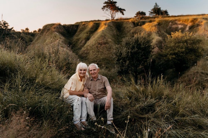 Mature couple smiling together on a scenic grassy hillside