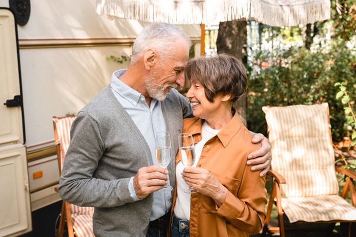 Senior couple enjoying a warm moment together beside their camper