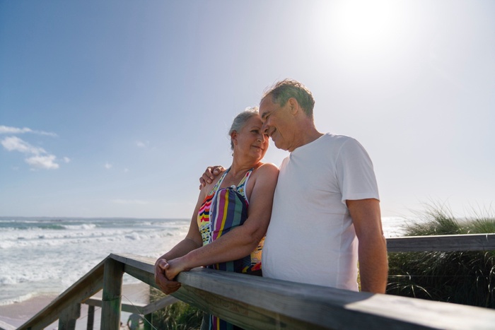 Mature couple on a sunny coastal beach boardwalk