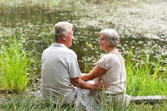 Older couple sitting by a wetland pond in Secaucus, New Jersey