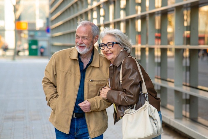 Senior couple walking arm in arm along a modern pedestrian area in Grand Junction, Colorado