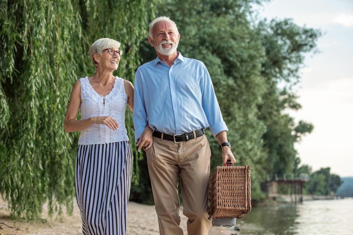 Older couple walking along the riverside in Ely, England