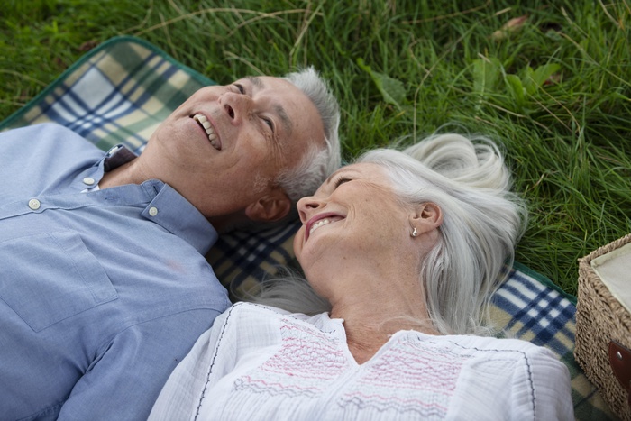 Mature couple relaxing together on a picnic blanket outdoors