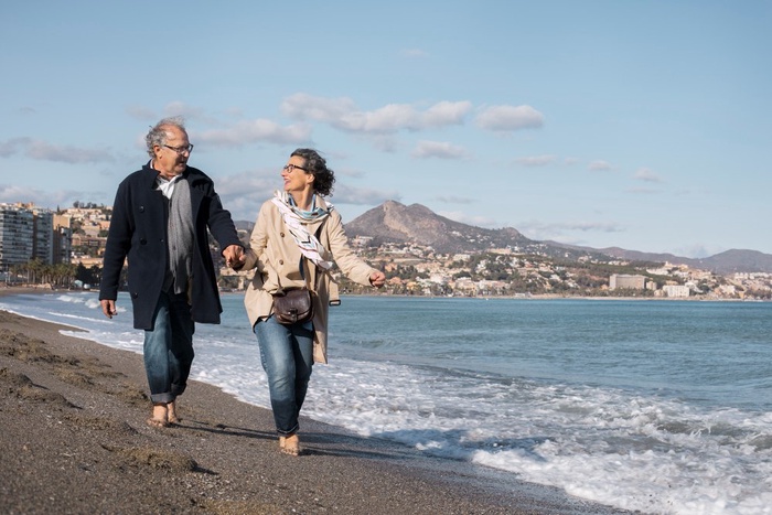 Mature couple enjoying a relaxed coastal walk along the shoreline