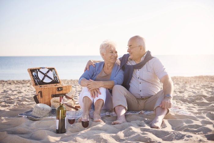 Senior couple enjoying a picnic together on the beach