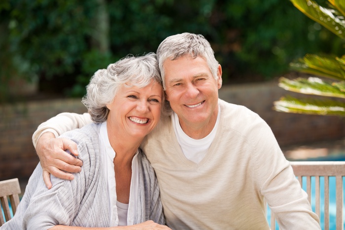 Older couple smiling together outdoors, reflecting companionship and a meaningful relationship after 50