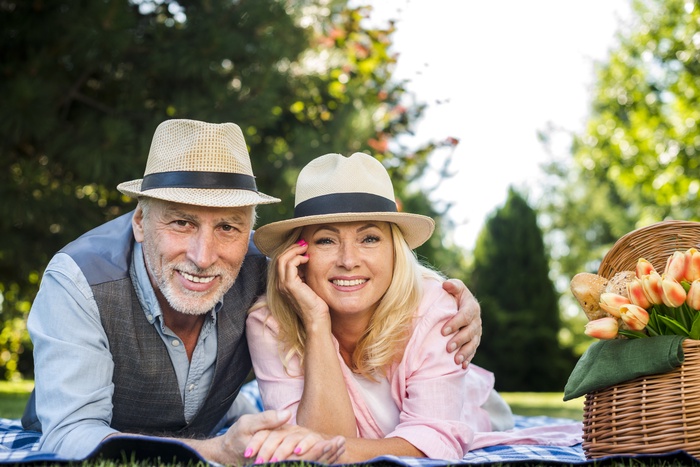 Senior couple over 50 enjoying a meaningful outdoor date together in a sunny park, representing companionship and mature dating.