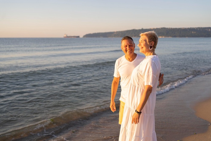 Older couple walking together along the beach at sunset in Weston-super-Mare, England