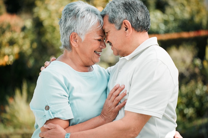A smiling senior couple in casual clothing enjoying a peaceful outdoor moment, representing companionship, love, and healthy aging.