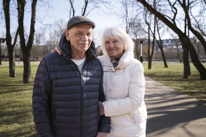 Older couple walking together on a leafy park path in a Central Florida setting
