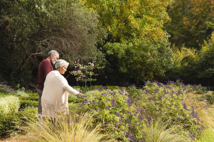 Older couple walking together through a colorful garden in Livingston, Scotland