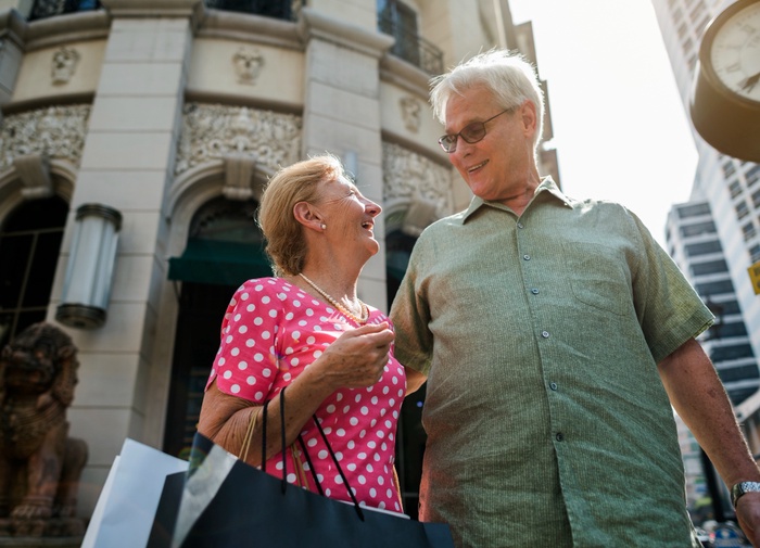 Older couple smiling together during a daytime city outing, illustrating dating over 50 in Trenton