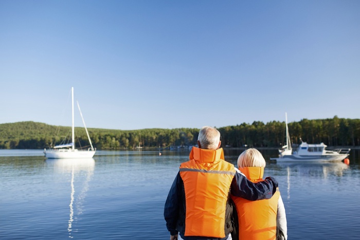 Mature couple looking out over calm waters and moored boats on Upper Lough Erne