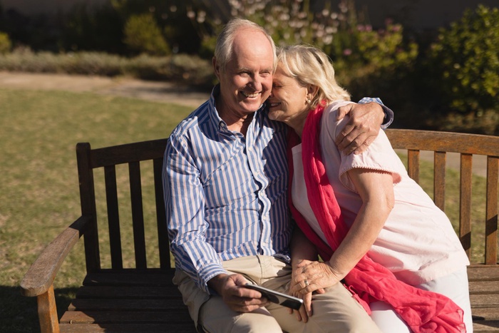 Senior couple sharing a happy moment together on a park bench