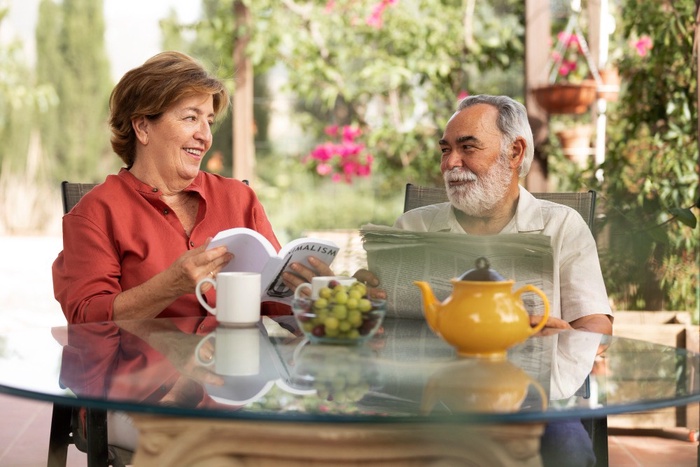Mature couple chatting over tea on a sunny patio