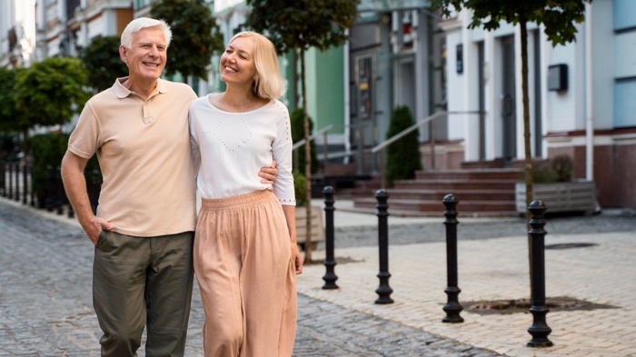 Older couple walking arm in arm outdoors