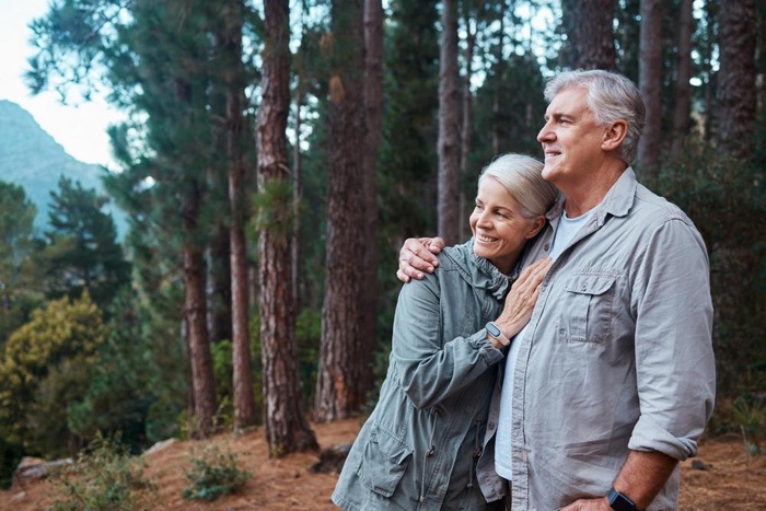 Older couple standing together in a wooded park in Broomfield, Colorado