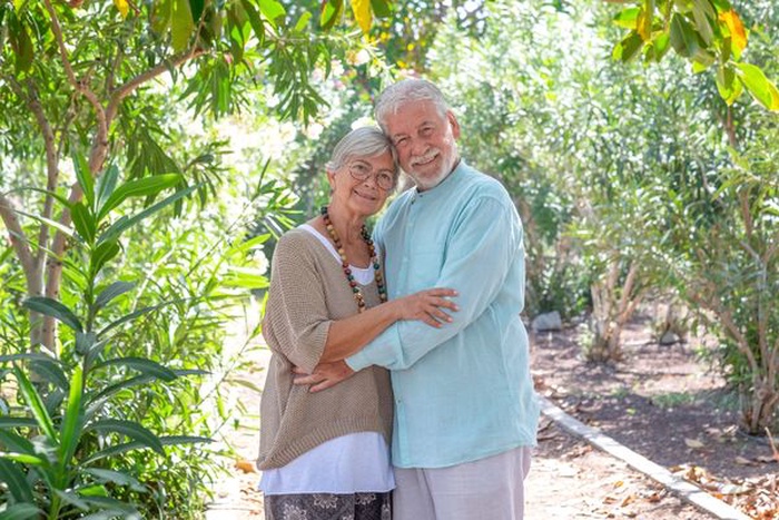 Senior couple smiling together in a leafy garden setting