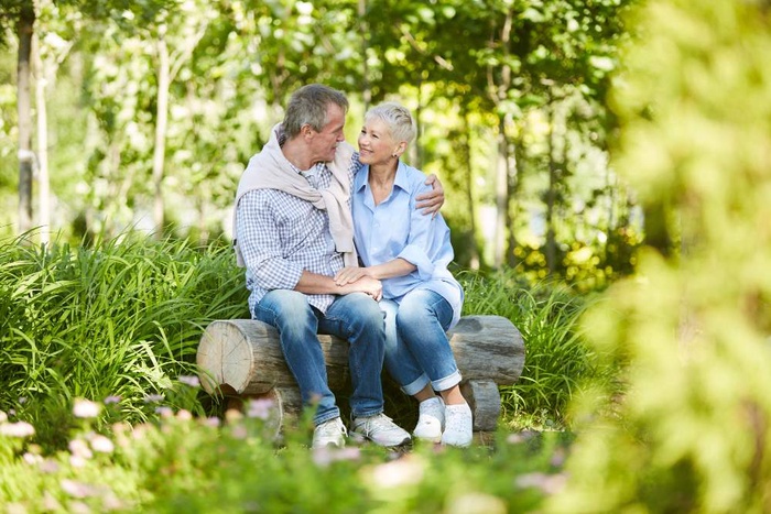 Older couple sitting together in a wooded park in Petersfield, England