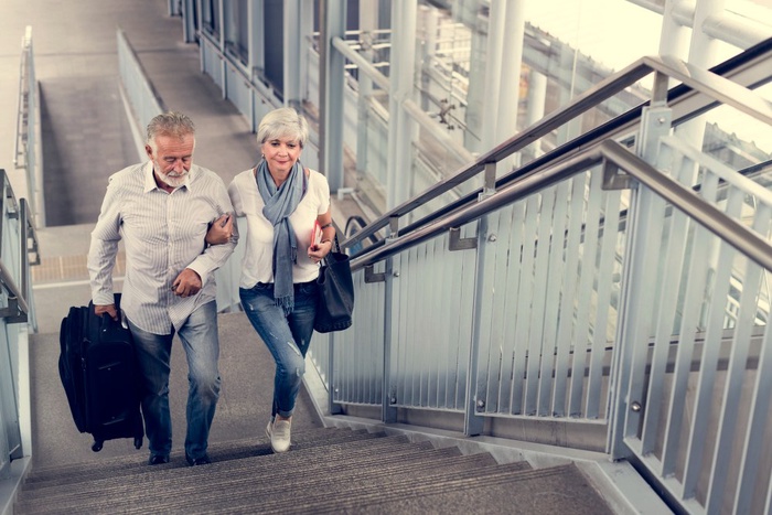 Mature couple travelling together by train before meeting locally