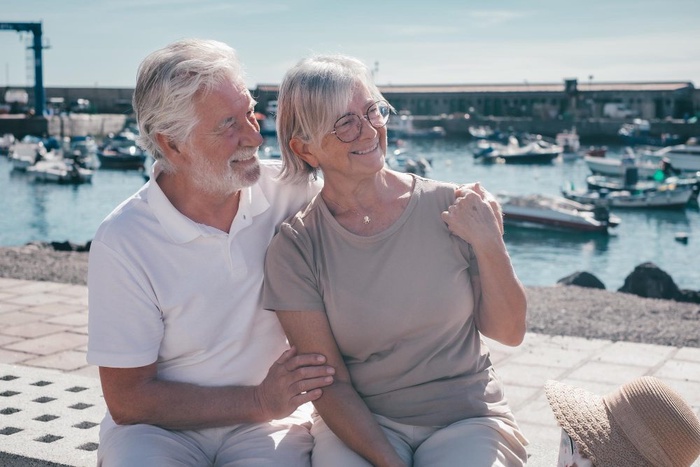 Older couple sitting by the harbor in Plymouth, Massachusetts