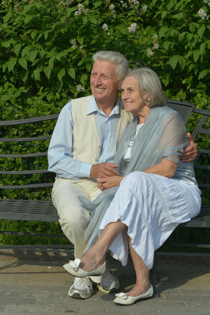Senior couple sitting together on a park bench