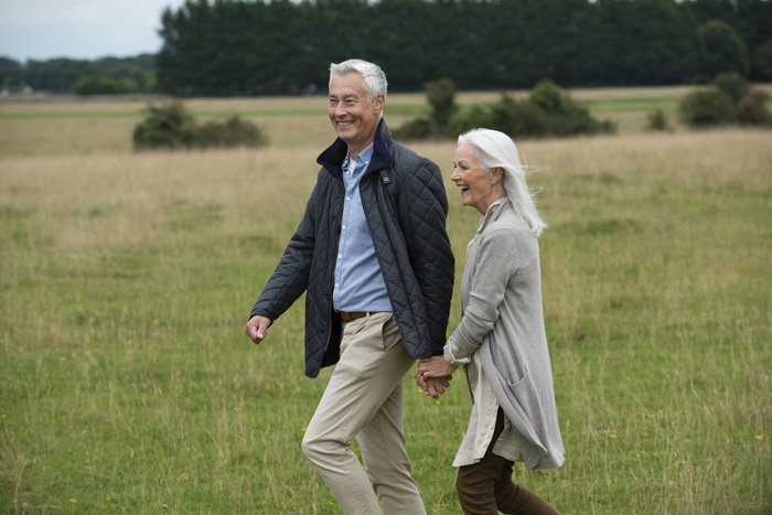 Two mature singles taking a walk across a grassy field in Iowa.