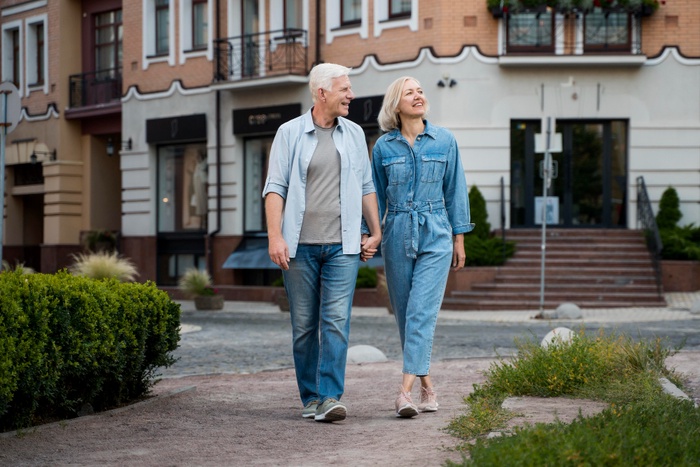 Senior couple holding hands while walking together through the Rose District in Broken Arrow, Oklahoma