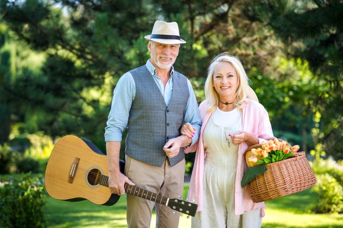 Mature couple with guitar walking in a Davie park