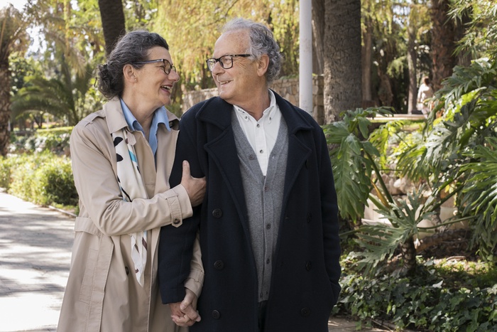 Mature couple over 50 enjoying a walk and conversation in a Bronx garden setting.
