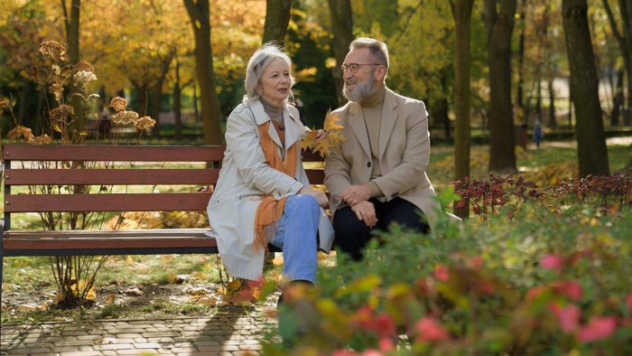 Senior couple talking on a park bench in an autumn setting near Founders Park in Johnson City, Tennessee
