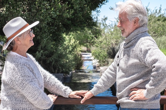 Senior couple smiling together outdoors by the water