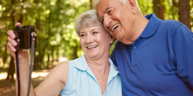 Happy older couple taking a selfie together outdoors