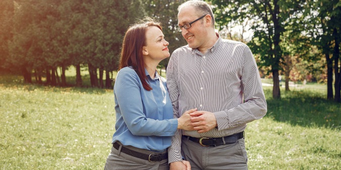 Mature couple walking and talking in a park