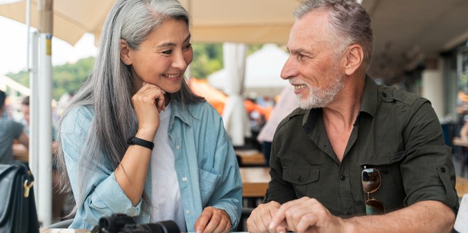 Mature couple over 50 enjoying a conversation over drinks