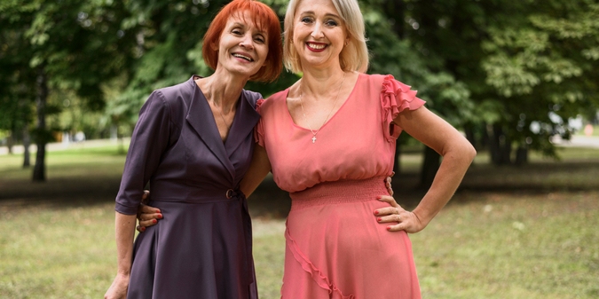 Mature lesbian couple smiling outdoors in park
