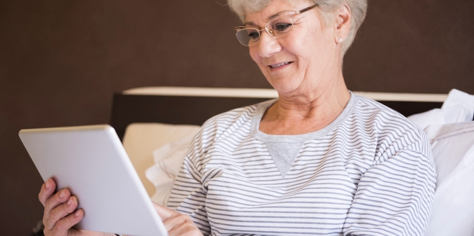 Woman over 50 browsing a tablet at home