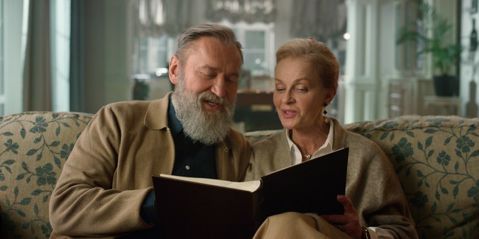 Older Catholic couple looking through a book together at home.